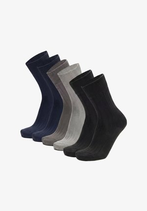 Sei paia di calzini a coste neri, grigio scuro, grigio chiaro e blu navy disposti uno accanto all'altro.