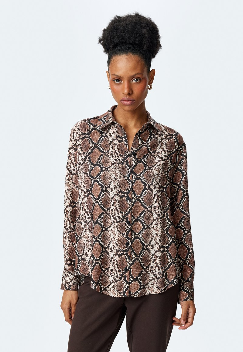 Camicia a maniche lunghe, con bottoni, in stampa rettile caratterizzata da tonalità di marrone, beige e nero su un tessuto liscio. Include un colletto e una vestibilità comoda.