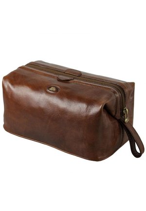 Trousse de toilette rectangulaire en cuir marron avec fermeture éclair et une sangle au poignet sur le côté, texture lisse avec un petit patch logo ovale sur le dessus.