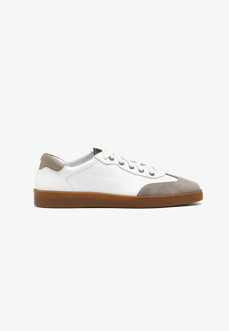 Białe skórzane sneakersy z szarym zamszowym czubkiem, brązową gumową podeszwą i sześcioma oczkami do sznurowania. Posiadają kontrastującą tylnią pętelkę.