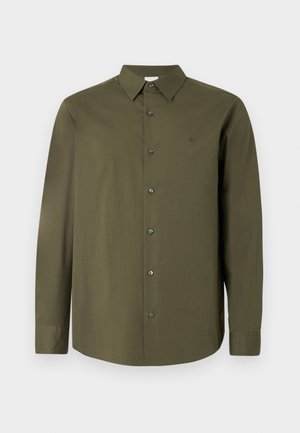 Tamsiai alyvuogių spalvos marškiniai ilgomis rankovėmis su aštriomis apykaklėmis, juodais mygtukais ir subtiliu logotipu ant krūtinės. Lygus, vientisas audinio tekstūra.