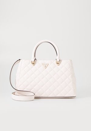 Sac à main matelassé blanc avec poignées supérieures et longue bandoulière, orné d'une petite plaque triangulaire avec le logo Guess au centre devant.