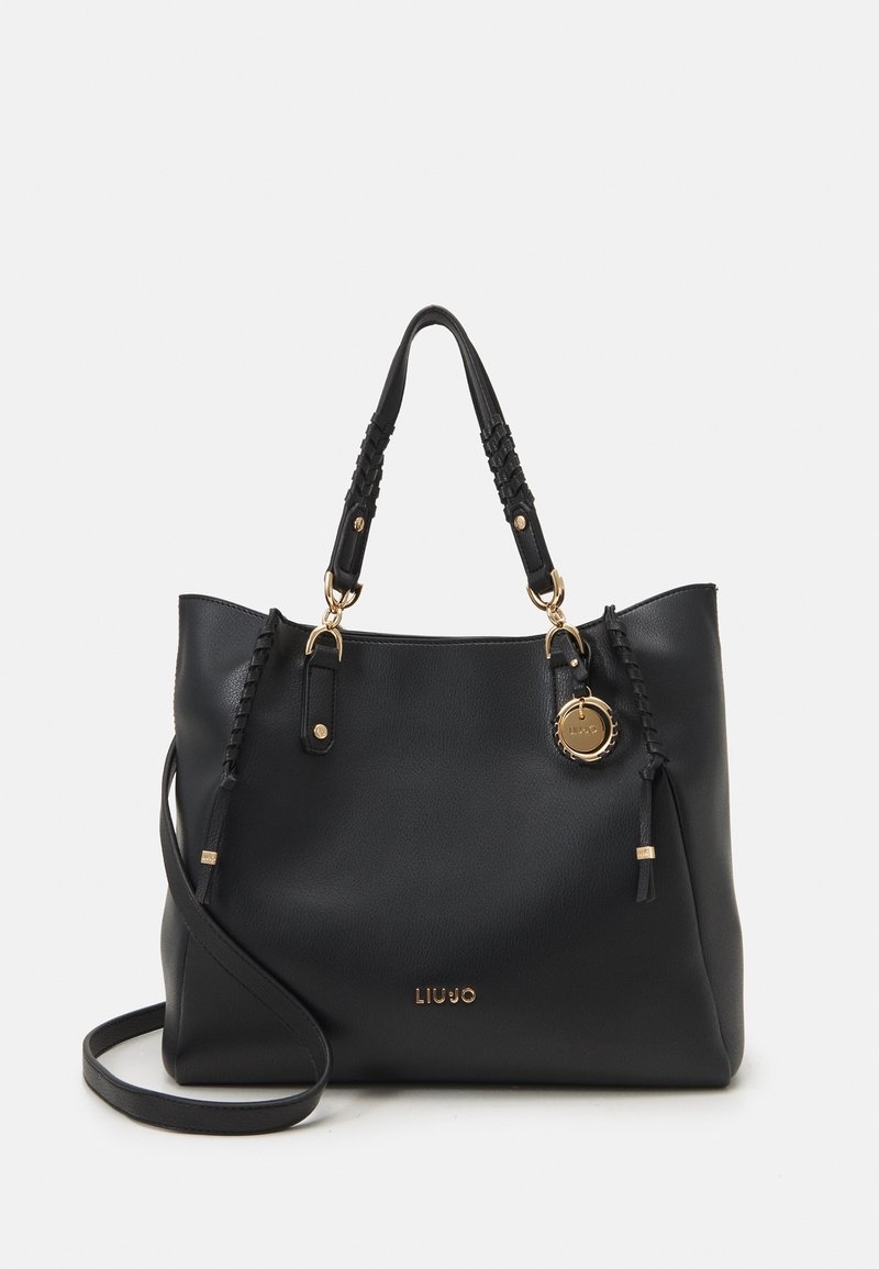 Borsa a tote in pelle nera con manici intrecciati, dettagli in metallo dorato e un pendente. Presenta un ampio interno e un logo discreto.