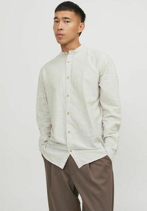 Camicia button-down con strisce leggere, colletto alla coreana, nei colori beige e bianco, con bottoni dorati lungo il davanti e maniche lunghe.
