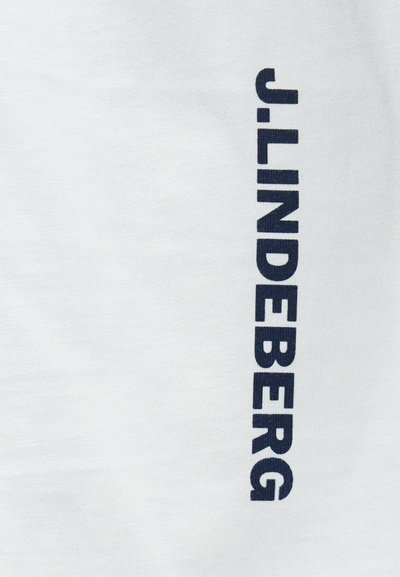 Baltos medvilnės marškinėliai su ryškiais tamsiai mėlynais vertikaliais užrašais "J. LINDEBERG." Lygi tekstūra, klasikinis apvalus iškirpimas.