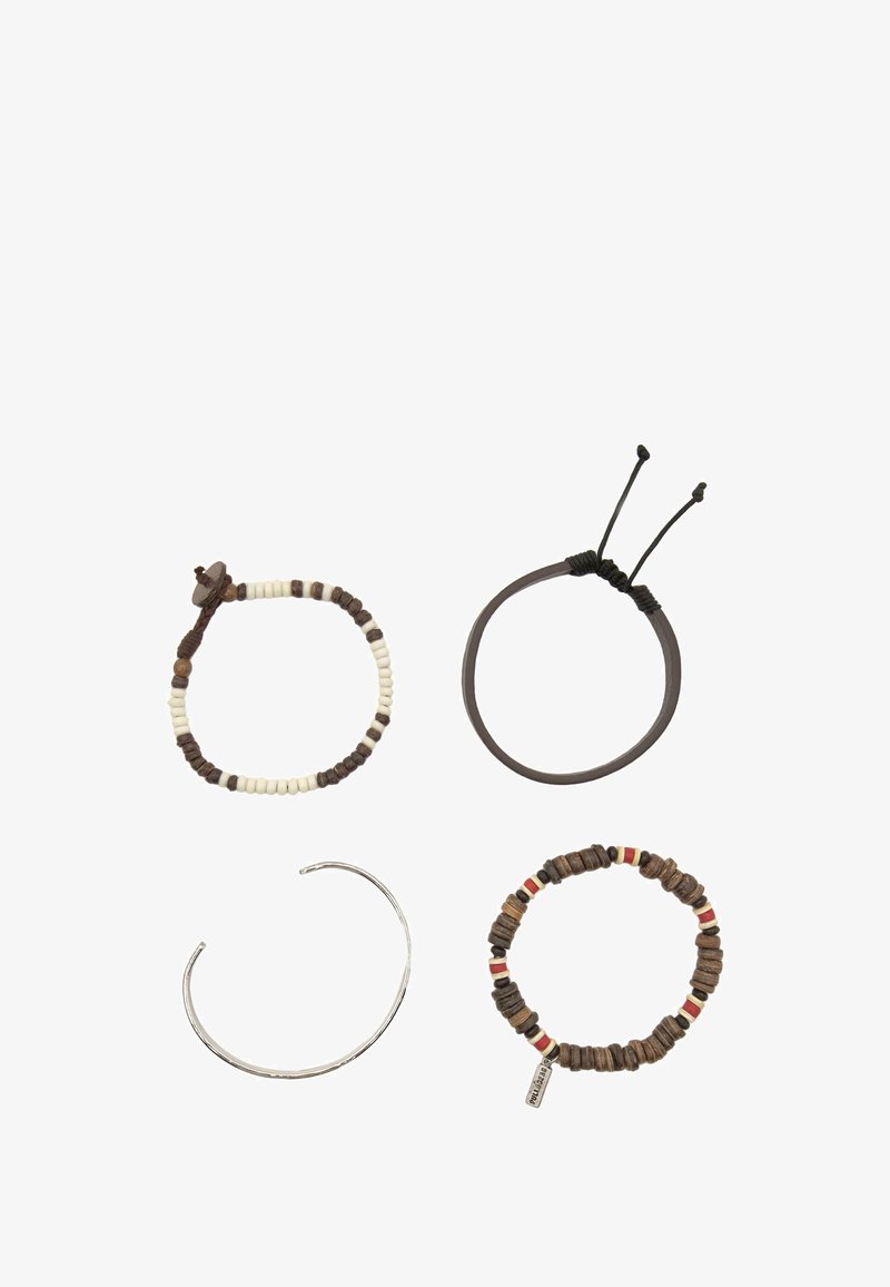 Quattro braccialetti: uno con perline bianche e marroni, una fascia elastica marrone, un bracciale cuff in argento e un bracciale multicolore con perline e un’etichetta.