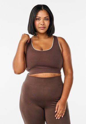 Bruine sportcrop top met witte afwerking, gecombineerd met bijpassende hoge taille legging. Gladde textuur, aansluitend ontwerp en minimale naden.