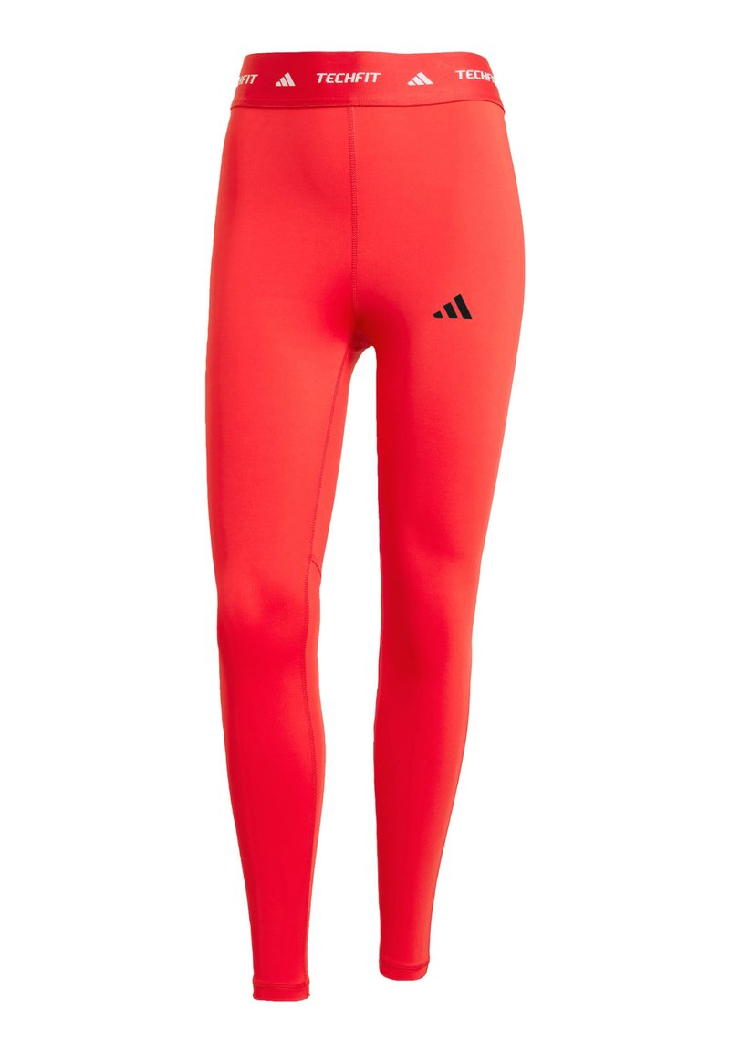 Leggings de compresión rojos con una cinturilla elástica, que presentan un logo y una marca en negro. Fabricados con un tejido suave y elástico.