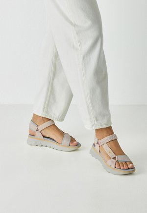 Light grey sandals with textured straps, adjustable back, and a chunky sole. Features color accents in blue and yellow.