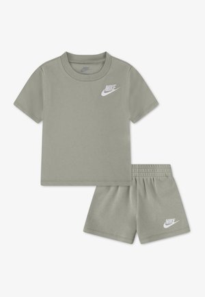 Gråt Nike børnesæt med T-shirt med korte ærmer og elastik i livet på shorts, med hvid Nike-logo på brystet og venstre ben.