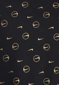 Černá látka s rozptýlenými zlatými logy Nike a kulatými vzory, která se vyznačuje hladkou texturou a opakujícím se moderním vzorem.