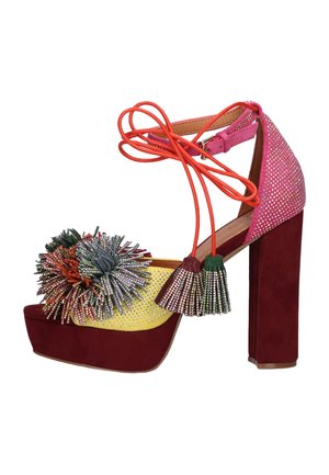 Sandalo con plateau e tacco alto bordeaux, tessuto glitter giallo e rosa, pon pon multicolore e cinturino alla caviglia arancione con nappine.