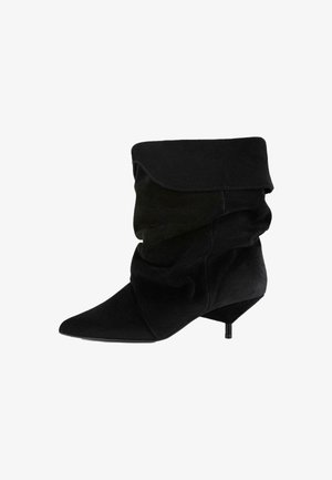 Zwarte, zachte stoffen enkellaars met een slouchy ontwerp, spitse neus en een lage stilettohak. Kenmerkt zich door gelaagde, gedrapeerde details aan de bovenkant.