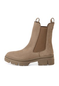 Bottine Chelsea en cuir suédé beige avec panneau latéral élastique, bout arrondi et semelle en caoutchouc avec bande de roulement texturée. Tirants de chaque côté pour un enfilage facile.