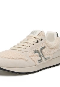 Sneakers in suede beige con accenti testurizzati soffici, lacci tonalità e un logo argentato. Suola in gomma nera con dettagli di trazione.