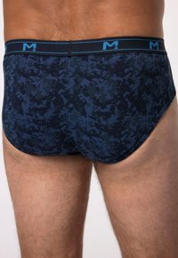 Slip da uomo blu camouflage con elastico nero caratterizzato da un logo blu. Il tessuto appare liscio con un design aderente.