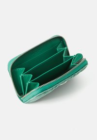 Green leather wallet featuring a quilted design with a zipper closure. Interior includes multiple card slots and a smooth, lined finish.