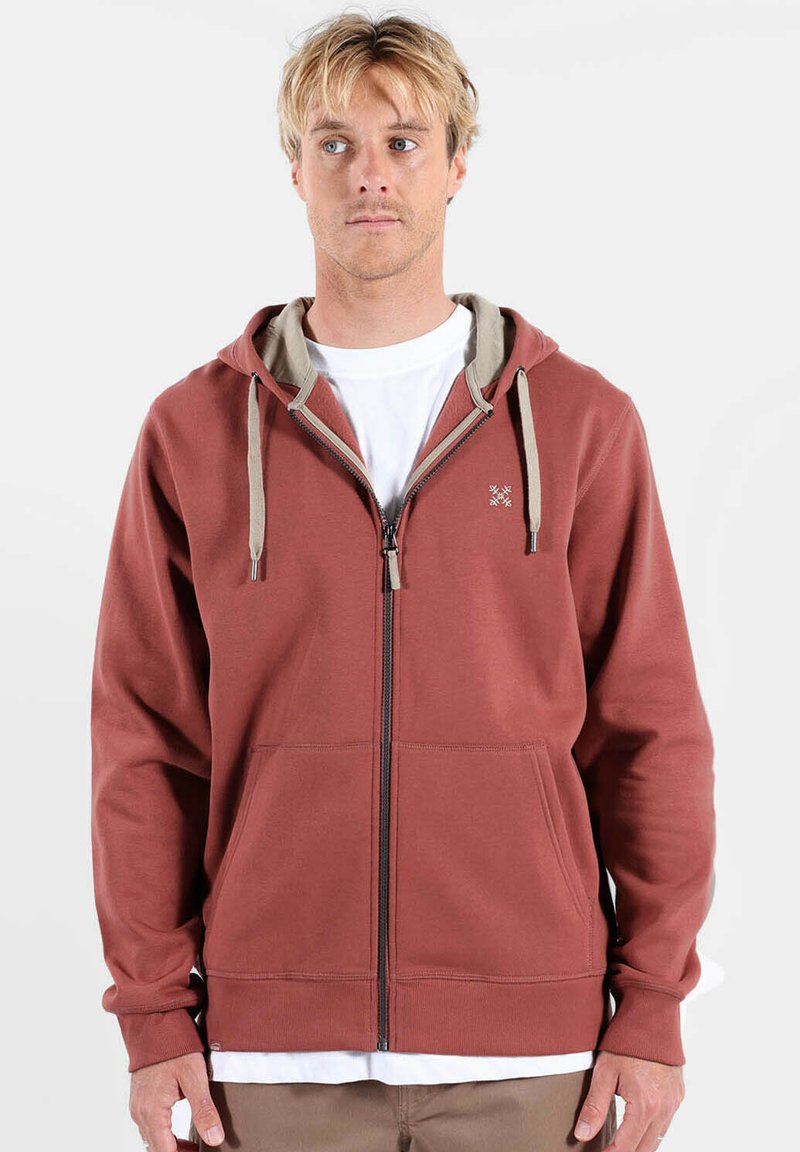 Sweat à capuche rouge avec fermeture éclair, cordons beiges et doublure intérieure beige, doté de deux poches avant et d'un logo brodé sur la poitrine.