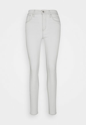 Schmale Jeans aus hellgrauem Denim, mit hoher Taille, vorderen Taschen und einem einzelnen Knopfverschluss. Glatte Textur mit minimalen Details.