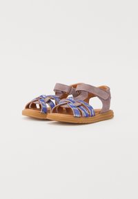 Lilla og blå barnesandaler med overdel i semsket skinn, åpen tådesign, teksturerte stropper og fleksibel gummisåle. Borrelås-lukking.