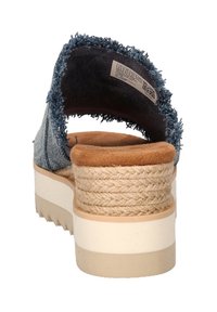 Hakken sandaal met een denim bovenkant, rafelige randen en een gevlochten jute hak. Crème rubberen zool met een gestructureerde grip. Gevoerde binnenzool voor comfort.