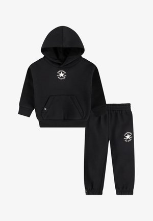 Set van zwarte hoodie en trainingsbroek gemaakt van zachte stof. De hoodie heeft een kangaroozak en een wit logo. De broek heeft elastische boorden en tailleband.