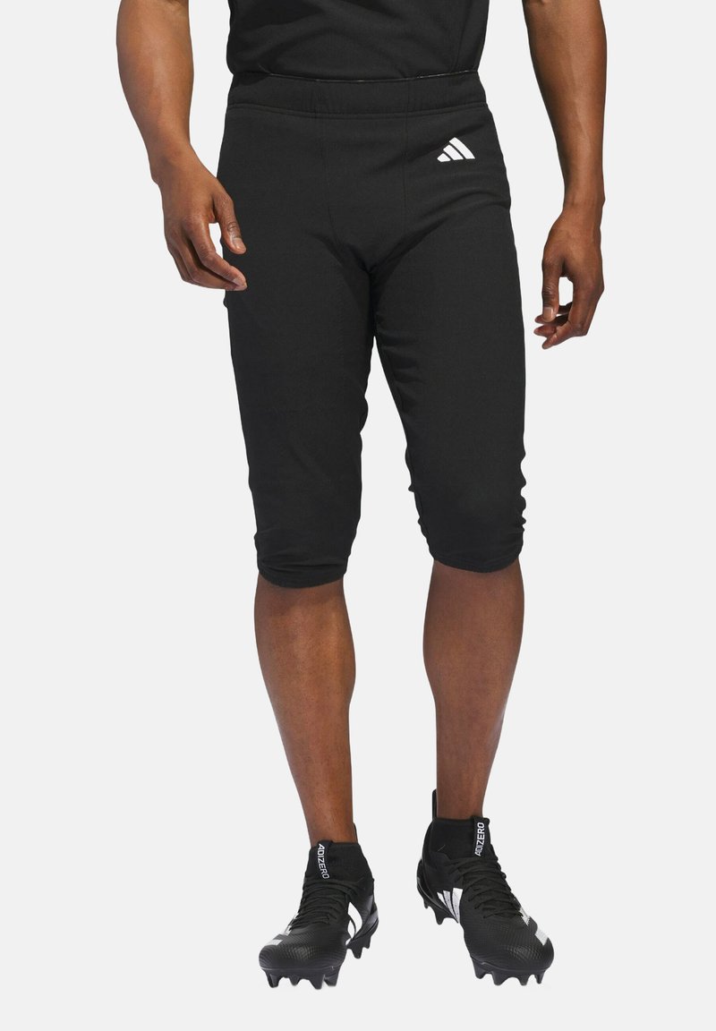 Black athletic shorts with a tapered design, made of stretchy material. Features an elastic waistband and a white Adidas logo on the left thigh.