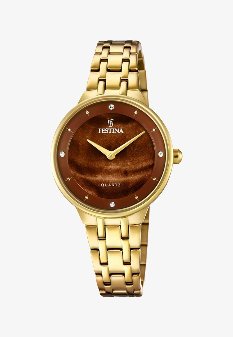 Reloj de pulsera de metal dorado con esfera redonda, dial marrón, movimiento de cuarzo y acentos de cristal. Presenta manecillas y logo en dorado.