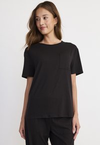 Czarny t-shirt z krótkim rękawem, wykonany z miękkiej bawełny, z okrągłym dekoltem i kieszonką na piersi z wyszytym logo marki.