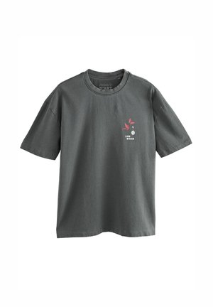 T-shirt à manches courtes gris foncé avec un petit papillon rouge et un design de texte blanc sur la partie gauche de la poitrine.