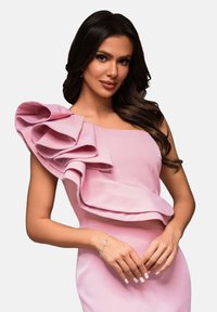 Robe rose avec un décolleté carré et un grand détail volanté asymétrique sur une épaule. Tissu lisse avec une silhouette ajustée.