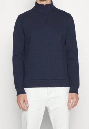 Navyblauer Pullover mit einem Viertelreißverschluss-Kragen, langen Ärmeln, gerippten Bündchen und einem Logo auf der Brust. Hergestellt aus weichem, strukturiertem Stoff.