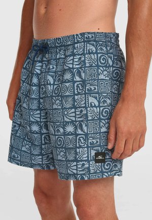 Modré vzorované plavkové šortky s elastickým pásom a sťahovacou šnúrkou, ktoré nosí muž, s logom značky O'Neill na nohe.