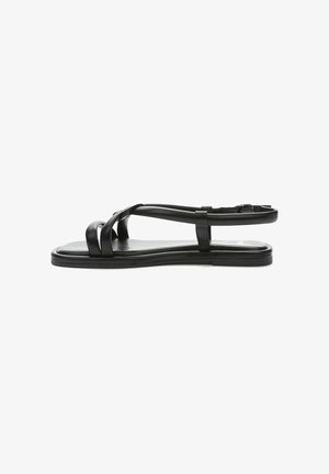Black flat sandals featuring cross straps, a smooth leather finish, and an adjustable ankle strap. Simple, minimalistic design.