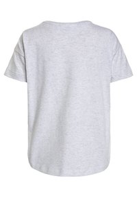 Světle šedé tričko s krátkým rukávem vyrobené z měkké tkaniny s hladkým povrchem. Má kulatý výstřih a volný střih.