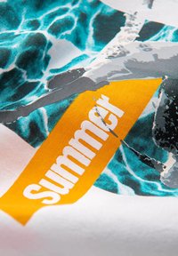 T-shirt i bomull med en turkos vatten grafik, med en kraftig gul etikett som visar ordet "Sommar" i vitt. Mjuk textur och klara färger.