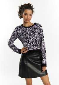 Pulover cu model leopard în nuanțe de purpură, negru și alb, cu guler rotund și mâneci lungi, purtat cu o fustă mini din piele neagră.