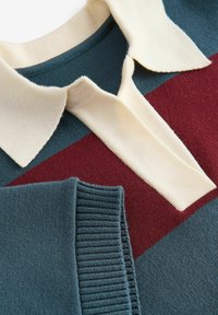 Sweter z kołnierzem w paski w kolorach turkusowym, burgundowym i kremowym. Miękka struktura z żebrowanymi mankietami i designem kołnierza zapinanego na fold-over.