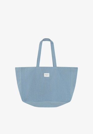 Sac cabas étroit à rayures bleues et blanches avec deux anses et une petite étiquette blanche au centre avant.