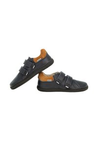 Sneakers blu navy per bambini con accenti in suede marrone sul tallone e doppie fibbie in Velcro, esposti uno accanto all'altro.