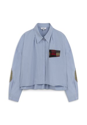 Camicetta cropped di colore azzurro chiaro realizzata in tessuto morbido. Presenta una tasca a toppa a quadretti e toppe ai gomiti con motivi multicolori. Chiusura con bottoni.