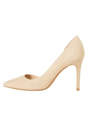 Zapato de tacón alto de ante beige con punta afilada y detalle lateral recortado. Presenta un tacón de aguja delgado y una textura exterior suave.