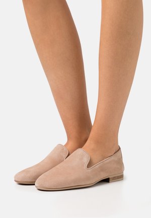 Beżowe zamszowe buty typu slip-on z zaokrąglonym noskiem i małym drewnianym obcasem. Gładka faktura z delikatnym przeszyciem wzdłuż otworu.