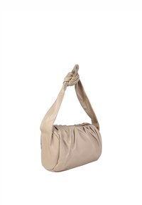 Beige læderhåndtaske med en knyttet skulderrem, der har en samlet tekstur og en rund form; enkelt, udekoreret design.