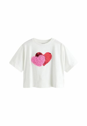 Tricou scurt cu mânecă scurtă, de culoare albă, cu două aplicații în formă de inimă: una roșie cu paiete și una pufoasă de culoare roz. Material din bumbac moale, croială lejeră.