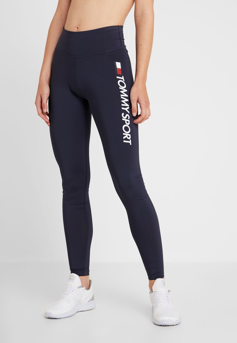 Marina leggings med hög midja, med en vit "TOMMY SPORT"-logotyp längs sidan och en mjuk, elastisk tygtextur.