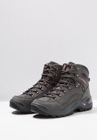 Graue Wanderschuhe mit strukturiertem Obermaterial, metallischen Ösen und rosa Schnürsenkeln. Merkmale sind ein hoher Schaft, eine Gummisohle und eine wasserabweisende Konstruktion.