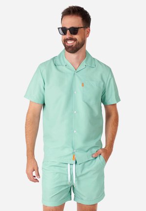 Mint green, short-sleeve button-up shirt with a pocket and orange tag. Paired with matching shorts featuring an elastic waistband and drawstring.