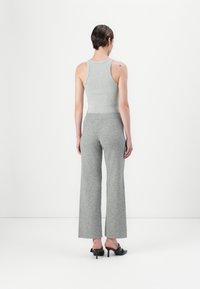 Top in maglia grigia a costine e pantaloni a gamba larga, entrambi realizzati in un materiale morbido, con una vestibilità casual e una vita alta. Design minimalista.