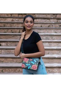 Florale Umhängetasche mit grauem Hintergrund, verziert mit rosa Rosen und blauen Schmetterlingen, in rechteckiger Form mit einem abnehmbaren Riemen.